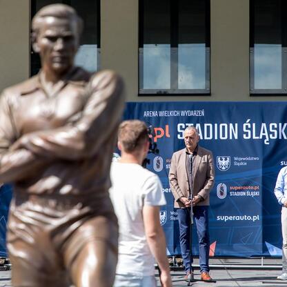 Statua biegacza przed Superauto.pl Stadionem Śląskim, w tle logo Silesia Marathon. (wygenerowano przez AI)