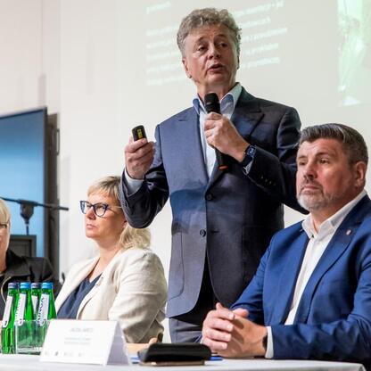 Panel dyskusyjny w Czechowicach-Dziedzicach, gdzie przedstawiciele lokalnych władz, ekspertów i społeczeństwa omawiają plany adaptacji do zmian klimatu dla Śląska. (wygenerowano przez AI)