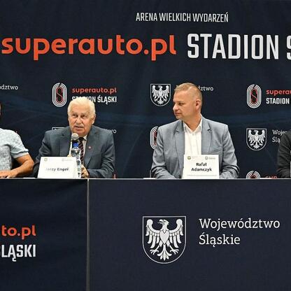 Członek Zarządu Województwa Rafał Adamczyk prowadzi konferencję prasową z udziałem legend polskiej i niemieckiej piłki nożnej na Superauto.pl Stadion Śląski. (wygenerowano przez AI)
