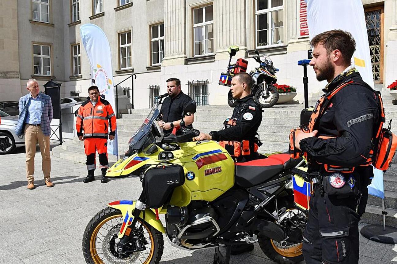 Wicemarszałek Leszek Pietraszek i radny Sejmiku Adam Lubas uczestniczą w przekazaniu nowego motoambulansu dla Wojewódzkiego Pogotowia Ratunkowego w Katowicach. (wygenerowano przez AI)
