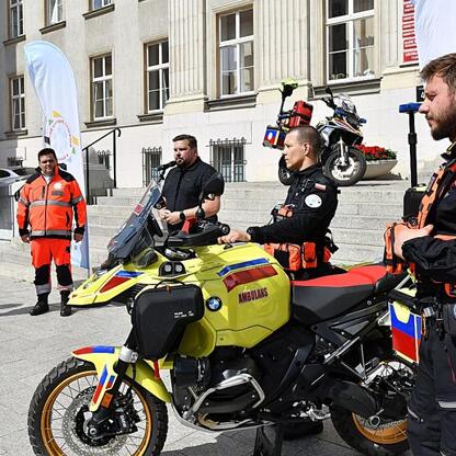 Wicemarszałek Leszek Pietraszek i radny Sejmiku Adam Lubas uczestniczą w prezentacji nowego motocyklu ambulansowego BMW R1300GS dla Wojewódzkiego Pogotowia Ratunkowego w Katowicach. (wygenerowano przez AI)