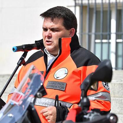 Dyrektor Łukasz Pach przemawia na uroczystości wojewódzkiego pogotowia ratunkowego w Katowicach. (wygenerowano przez AI)