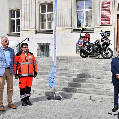 Wicemarszałek Leszek Pietraszek i radny Sejmiku Adam Lubas uczestniczą w przekazaniu nowego motocykla ratunkowego dla Wojewódzkiego Pogotowia Ratunkowego w Katowicach. (wygenerowano przez AI)