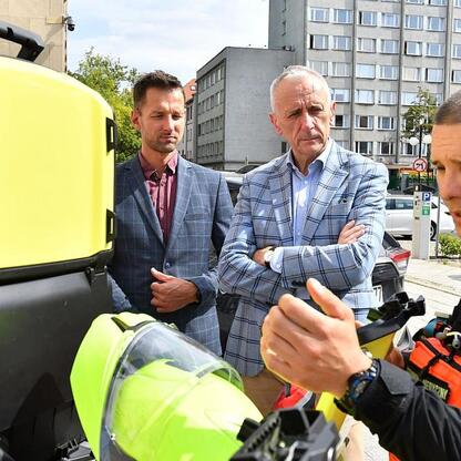 Wicemarszałek Leszek Pietraszek i radny Sejmiku Adam Lubas omawiają nowy motocykl-ambulans z paramedicem. (wygenerowano przez AI)