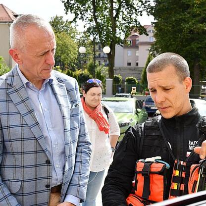 Wicemarszałek Leszek Pietraszek obserwuje paramedica z nowym motocyklem pogotowia ratunkowego. (wygenerowano przez AI)