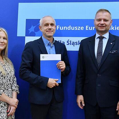 Rafał Adamczyk i Joanna Bojczuk wręczają certyfikaty uczestnikom programu Fundusze Europejskie dla Śląska 2021-2027. (wygenerowano przez AI)