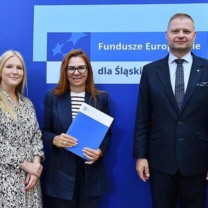 Rafał Adamczyk i Joanna Bojczuk wręczają listy gratulacyjne w ramach programu Fundusze Europejskie dla Śląska 2021-2027. (wygenerowano przez AI)