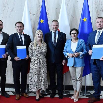 Członkowie Zarządu Województwa Śląskiego wręczają listy gratulacyjne za sukcesy w projekcie Fundusze Europejskie dla Śląskiego 2021-2027. (wygenerowano przez AI)