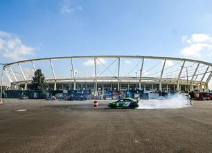 Rally car z hashtagiem #rajdslaska i logo European Rally Trophy, stojące przed Stadionem Śląskim w Katowicach. (wygenerowano przez AI)