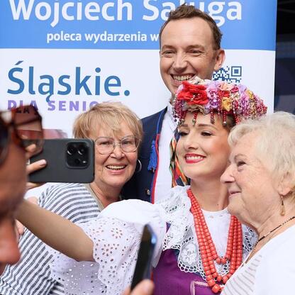 Silver Silesia festiwal w Chorzowie: Grupa seniorów robi selfie z artystą w tradycyjnym stroju. (wygenerowano przez AI)