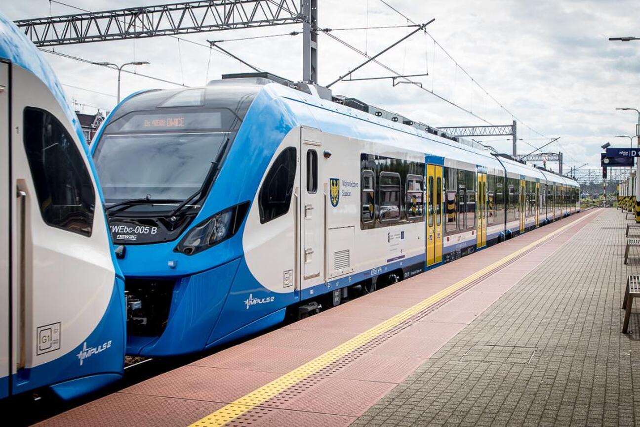 Nowy pociąg Newag Impuls 2 w barwach Kolei Śląskich na stacji kolejowej. (wygenerowano przez AI)