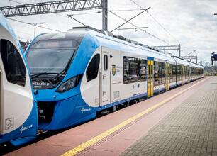 Nowy pociąg Newag Impuls 2 w barwach Kolei Śląskich na stacji kolejowej. (wygenerowano przez AI)