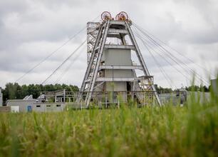 Zdjęcie przedstawia gigantyczny maszynę wydobywczą, prawdopodobnie rudy lub ropy naftowej, w otoczeniu pola zielonego. (wygenerowano przez AI)
