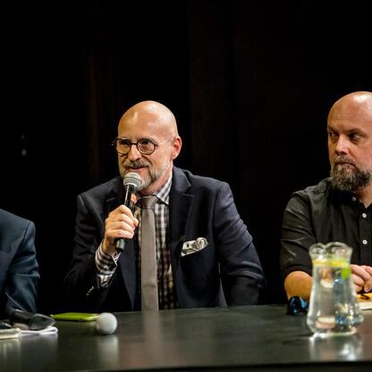 Panel dyskusyjny na Śląskim Stole w Teatrze Śląskim, gdzie przedstawiciele różnych sektorów omawiają strategie promocji Śląska. (wygenerowano przez AI)