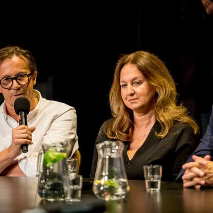 Trzy osoby uczestniczące w panelu dyskusyjnym podczas Śląskiego Stołu w Teatrze Śląskim. (wygenerowano przez AI)