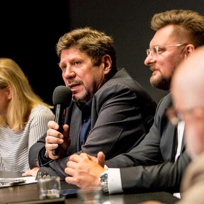 Panel dyskusyjny na Śląskim Stole w Teatrze Śląskim, gdzie przedstawiciele różnych środowisk dyskutują o promocji kultury i tożsamości Śląska. (wygenerowano przez AI)