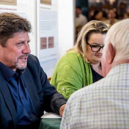 Trzech uczestników dyskutuje na Śląskim Stole, Teatr Śląski, rozmowy o regionalnym rozwoju i kulturze. (wygenerowano przez AI)
