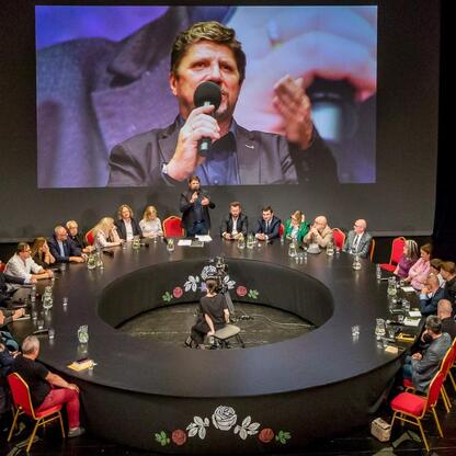 Panel dyskusyjny na Śląskim Stole w Teatrze Śląskim, gdzie przedstawiciele różnych sektorów dyskutują o przyszłości Śląska. (wygenerowano przez AI)