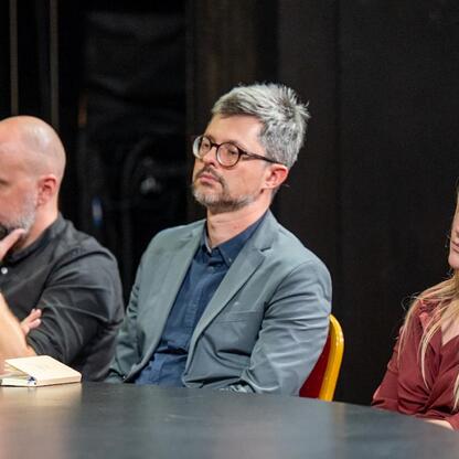 Panel dyskusyjny na Śląskim Stole w Teatrze Śląskim, gdzie przedstawiciele różnych środowisk dyskutują o przyszłości Śląska. (wygenerowano przez AI)