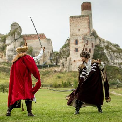 Rekonstrukcja starożytnego pojedynku na tle ruin zamku w Olsztynie. (wygenerowano przez AI)