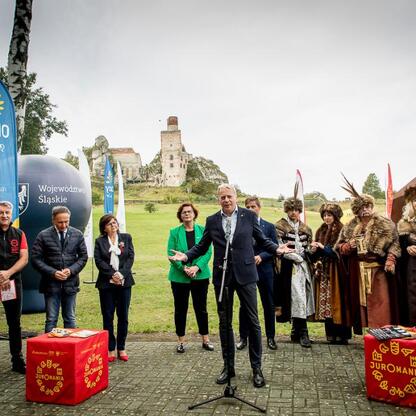 Wojciech Saługa, Marszałek Województwa Śląskiego, prowadzi konferencję prasową Juromania, festiwal jurajski w Olsztynie. (wygenerowano przez AI)