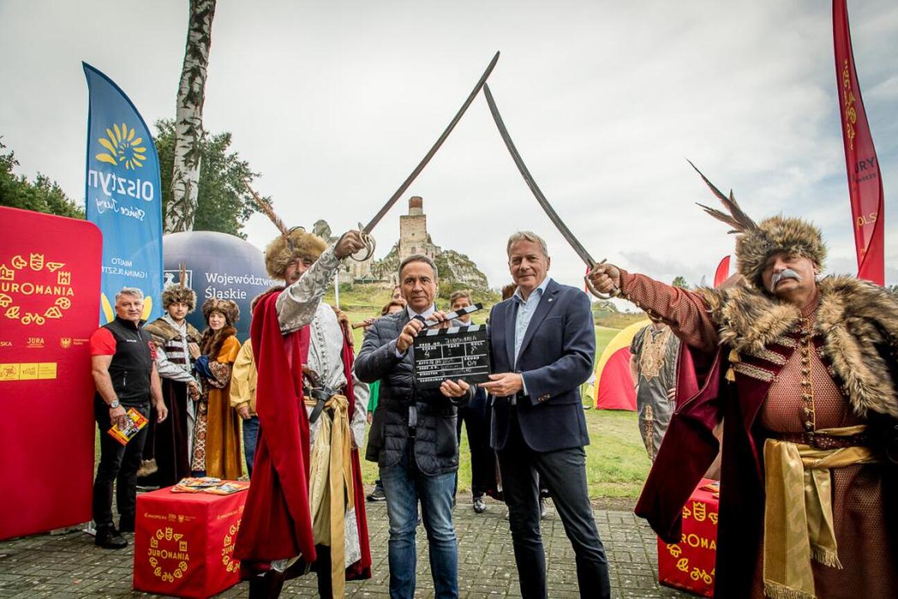 Ludzie w strojach średniowiecznych walczą na tle ruin zamku w Olsztynie, uczestnicząc w festiwalu Juromania. (wygenerowano przez AI)
