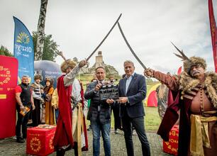 Ludzie w strojach średniowiecznych walczą na tle ruin zamku w Olsztynie, uczestnicząc w festiwalu Juromania. (wygenerowano przez AI)