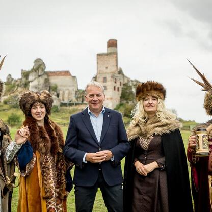 Grupa ludzi w strojach historycznych uczestniczy w Juromanie, festiwalu jurajskiego dziedzictwa w Olsztynie. (wygenerowano przez AI)