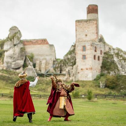 Ludzie w strojach średniowiecznych walczą na tle ruin zamku w Olsztynie, uczestnicząc w festiwalu Juromania. (wygenerowano przez AI)