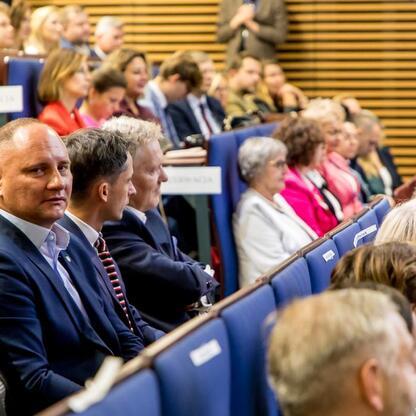 Śląski Kongres Oświaty, uczestnicy w niebieskich krzesłach, debata o przyszłości edukacji. (wygenerowano przez AI)