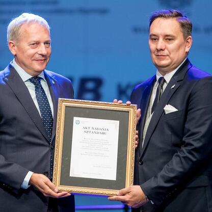 Wojciech Saługa, marszałek Województwa Śląskiego, wręcza sztandar Sosnowieckiemu pogotowiu ratunkowemu. (wygenerowano przez AI)