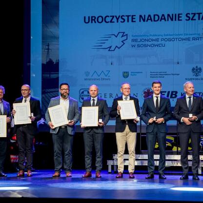 Marszałek Wojciech Saługa uczestniczy w uroczystości nadania sztandaru dla SPZOZ Rejonowego Pogotowia Ratunkowego w Sosnowcu. (wygenerowano przez AI)
