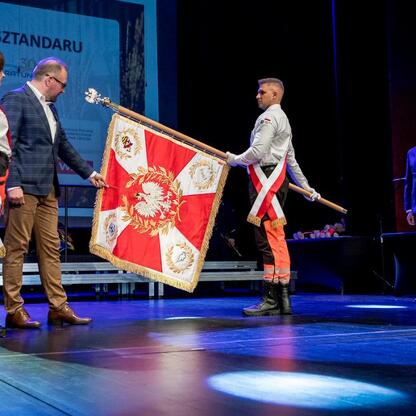 Marszałek Wojciech Saługa prezentuje sztandar na uroczystości 30-lecia SPZOZ w Sosnowcu. (wygenerowano przez AI)