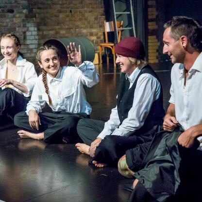 Grupa czterech artystów na scenie Kulturatrium, pracujących nad interdyscyplinarnym performensem 