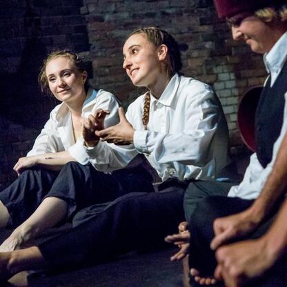 Występujący na scenie artysta w tradycyjnym stroju, uczestnicząc w interdyscyplinarnym performancie 