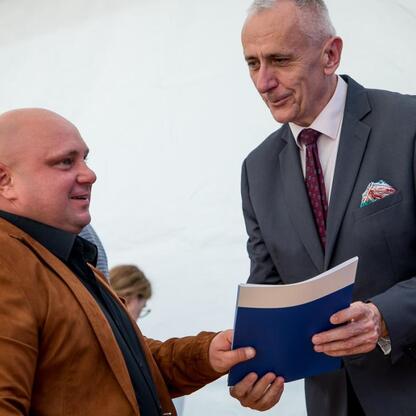 Leszek Pietraszek, wicemarszałek Województwa Śląskiego, prezentuje symboliczne czeki sportowcom na Superauto.pl Stadionie Śląskim. (wygenerowano przez AI)