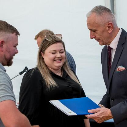 Wicemarszałek Leszek Pietraszek prezentuje symboliczne czek przedstawicielce klubu sportowego podczas uroczystości na Superauto.pl Stadionie Śląskim. (wygenerowano przez AI)