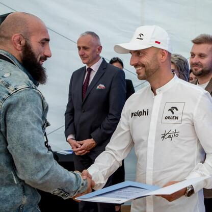 Wicemarszałek Leszek Pietraszek wręcza symboliczne czeki przedstawicielom 154 klubów sportowych na Superauto.pl Stadion Śląskim. (wygenerowano przez AI)