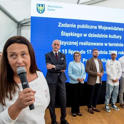 Wicemarszałek Leszek Pietraszek wręcza symboliczne czeki przedstawicielom 154 klubów sportowych na Superauto.pl Stadionie Śląskim. (wygenerowano przez AI)