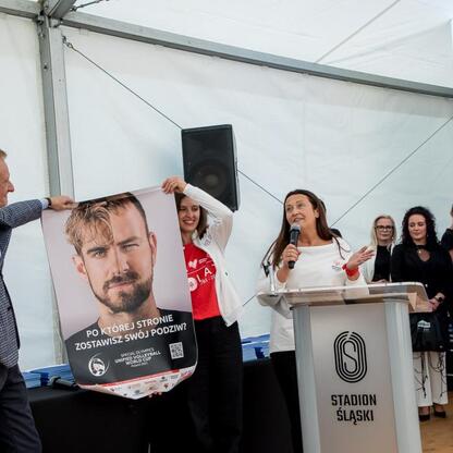 Wicemarszałek Leszek Pietraszek wręcza symboliczne czeki przedstawicielom 154 klubów sportowych na Superauto.pl Stadionie Śląskim. (wygenerowano przez AI)