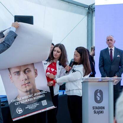 Wicemarszałek Leszek Pietraszek wręcza symboliczne czeki przedstawicielom 154 klubów sportowych na Superauto.pl Stadionie Śląskim. (wygenerowano przez AI)