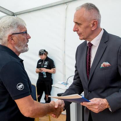 Leszek Pietraszek, wicemarszałek Województwa Śląskiego, wręcza symboliczne czeki przedstawicielom 154 klubów sportowych na Superauto.pl Stadionie Śląskim. (wygenerowano przez AI)