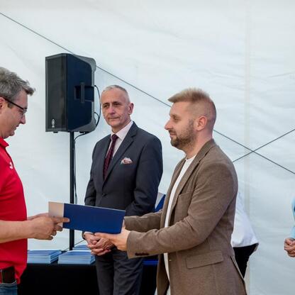 Wicemarszałek Leszek Pietraszek i przedstawiciele klubów sportowych podczas symbolicznych prezentacji czeków na Superauto.pl Stadionie Śląskim. (wygenerowano przez AI)
