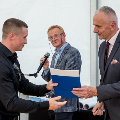 Leszek Pietraszek, wicemarszałek Śląska, wręcza symboliczne czeki przedstawicielom 154 klubów sportowych na Superauto.pl Stadionie Śląskim. (wygenerowano przez AI)