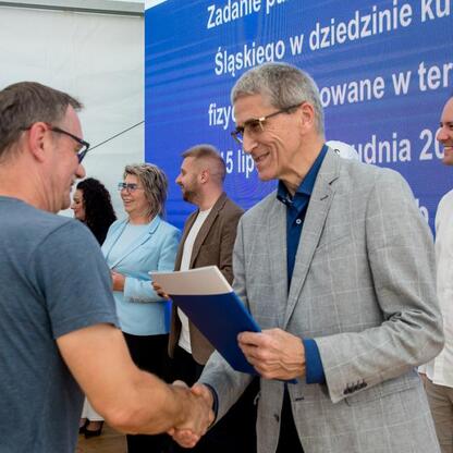 Leszek Pietraszek, wicemarszałek Śląska, wręcza symboliczne czeki przedstawicielom 154 klubów sportowych na Superauto.pl Stadionie Śląskim. (wygenerowano przez AI)