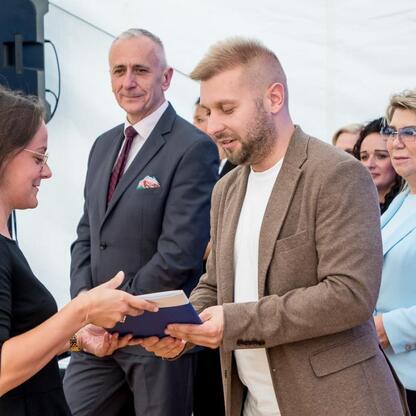 Wicemarszałek Leszek Pietraszek i przedstawiciele klubów sportowych podczas symbolicznych prezentacji czeków na Superauto.pl Stadionie Śląskim. (wygenerowano przez AI)