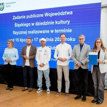 Wicemarszałek Leszek Pietraszek i przedstawiciele klubów sportowych podczas symbolicznych prezentacji czeków na Superauto.pl Stadionie Śląskim. (wygenerowano przez AI)