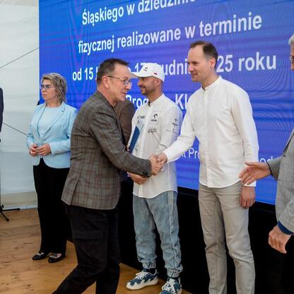 Wicemarszałek Leszek Pietraszek i przedstawiciele regionu podczas symbolicznych prezentacji czeków dla 154 klubów sportowych na Superauto.pl Stadionie Śląskim. (wygenerowano przez AI)