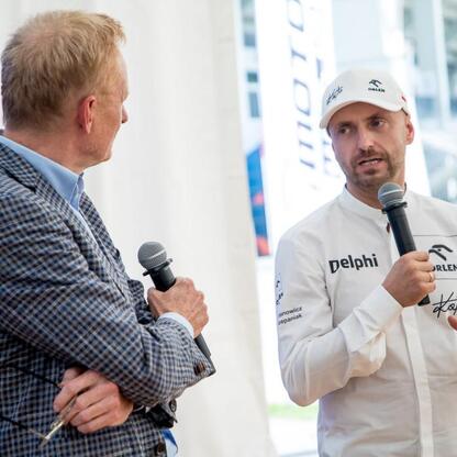 Dwa osoby rozmawiają na Stadionie Śląskim w ramach Programu Klub, wspierającym sportowe kluby regionu. (wygenerowano przez AI)