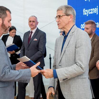 Wicemarszałek Leszek Pietraszek i przedstawiciele klubów sportowych podczas symbolicznych prezentacji czeków na Stadionie Śląskim. (wygenerowano przez AI)